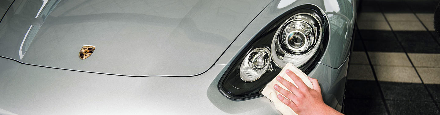 Premium Parking Close-up of a high-end car in the premium parking area at Munich Airport, with a hand gently polishing the headlight.