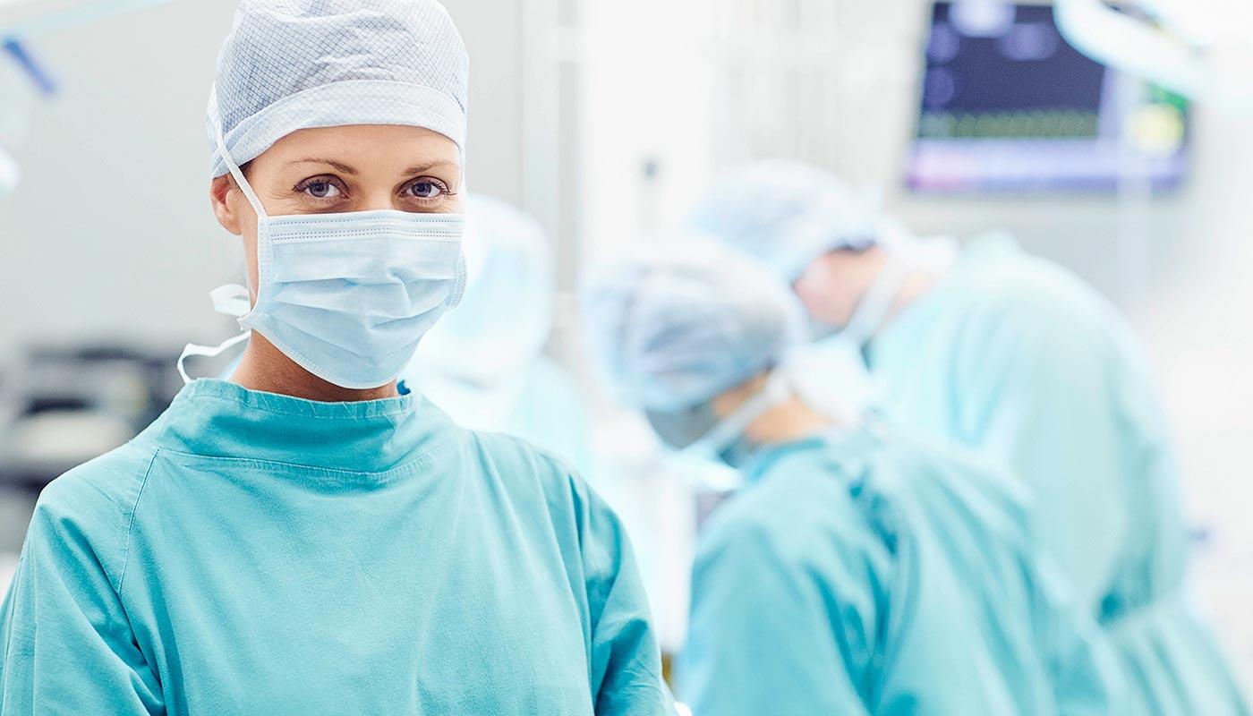 Medical Care Munich Airport – Fast & Reliable Doctor in surgical attire with medical team in background – safe and modern care at Munich Airport.
