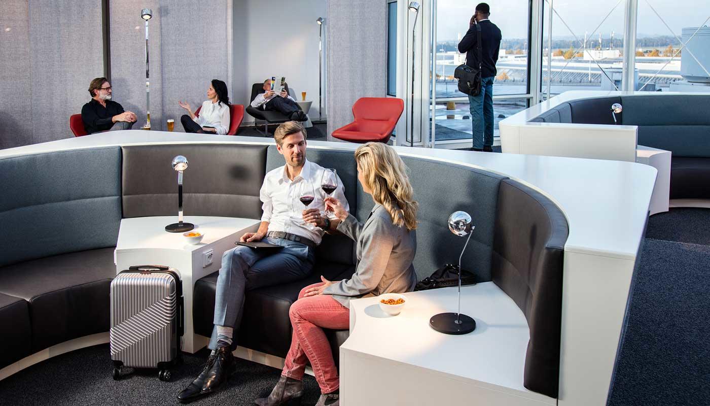 Airport Lounge World Airport Lounge World. Modern lounge with large windows, seating areas, and travelers enjoying drinks and relaxing