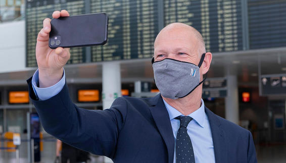 Flughafenchef Jost Lammers macht vor der Anzeigentafel im Terminal 1 ein Selfie