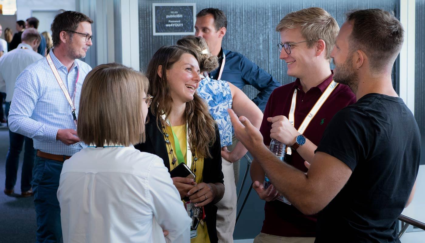 Events im ISH am Flughafen München Veranstaltungsteilnehmer stehen in einer kleinen Gruppe zusammen und unterhalten sich.