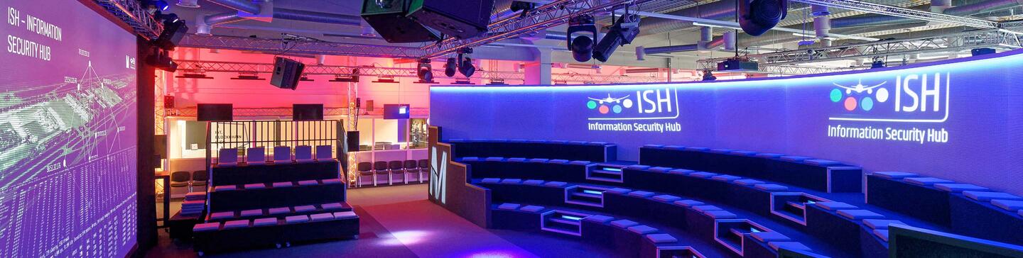ISH Event Location Auditorium in der Event Location ISH mit einer runden Haupttribüne und zwei seitlichen Tribünen sowie einer Großleinwand.