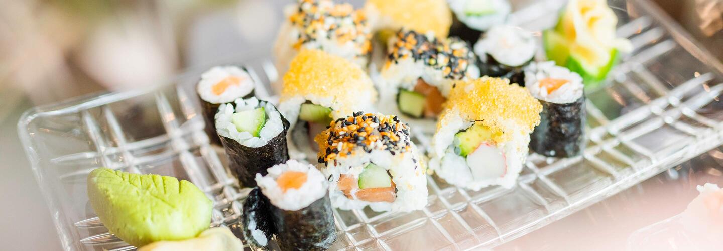Sushi Bunte Sushi-Auswahl mit Nigiri und Maki auf einem Drahtgitter angerichtet, begleitet von Wasabi und Ingwer. Die frische Zubereitung und leuchtenden Farben vermitteln hochwertigen internationalen Genuss am Flughafen München.