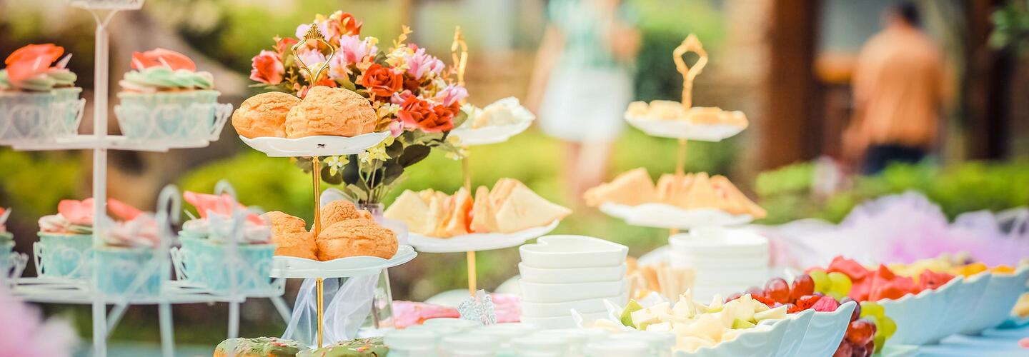 Familienfeier Reich gedecktes Buffet mit Etageren voller Gebäck, Obst, Sandwiches und kleinen Häppchen. Zarte Farben, frische Blumen und liebevolle Details erzeugen eine festliche, hochwertige und einladende Atmosphäre.