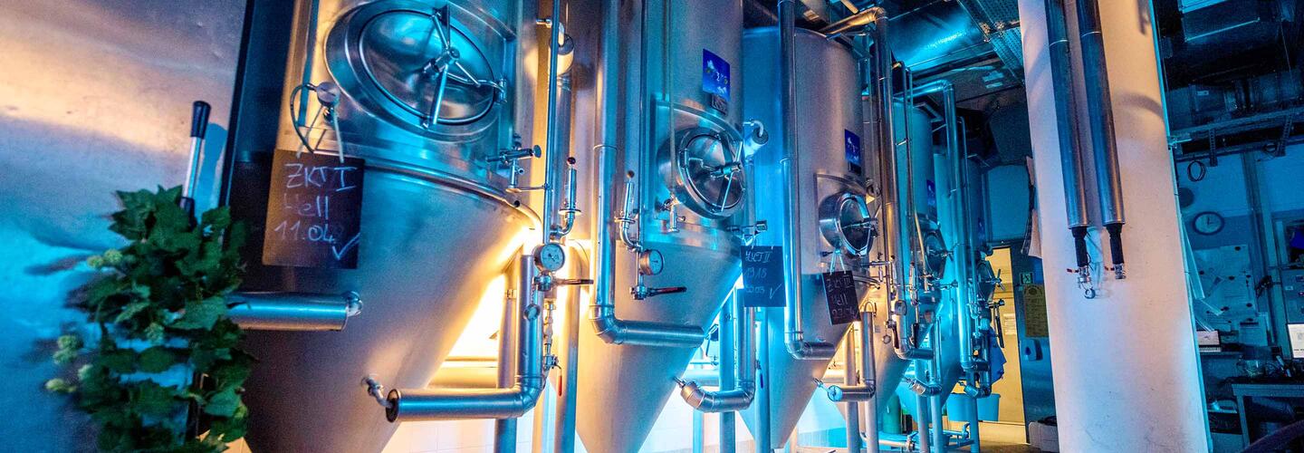 Airbräu brewery Technical equipment, pipes, and devices are installed in an atmospherically lit room. Blue-violet lights impressively highlight the airport's modern building technology.