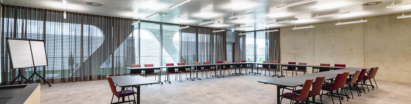 Seminarraum AirportAcademy Seminarraum mit Tischen und U-Bestuhlung, Flipchart und großer Fensterfront