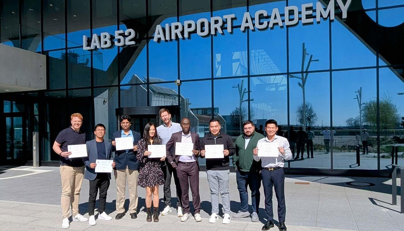 ORAT training participants Group of training participants standing with their trainer in front of the LAB 52 AirportAcademy building with training certificates in their hands.