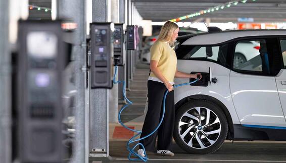 Frau lädt ihr Elektroauto im Parkhaus P44 an einer Ladesäule 