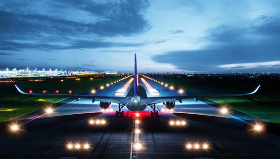 Passenger aircraft on an illuminated runway at night at Munich Airport, preparing for takeoff.