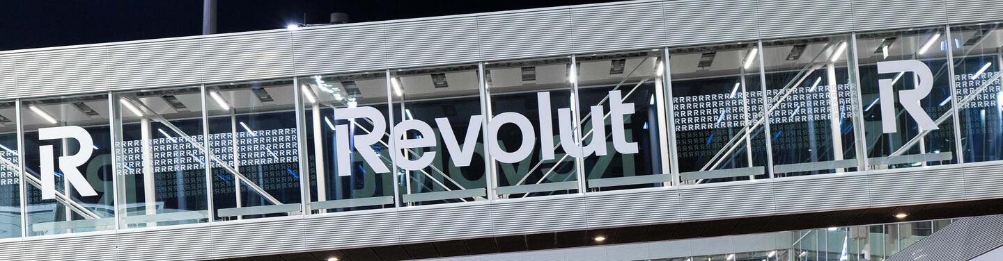 Revolut Branding White Revolut lettering on a glass connecting structure - from the terminal building to the passenger boarding bridges.