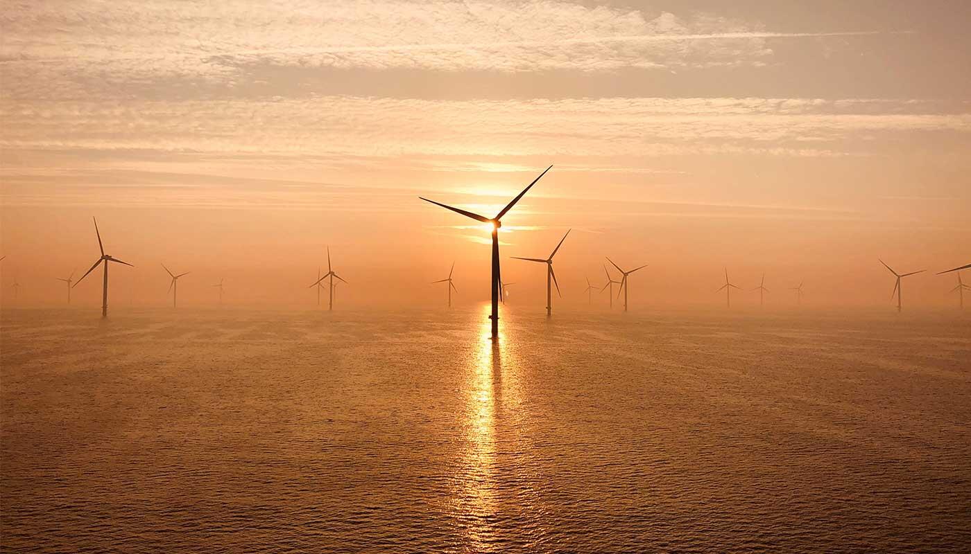 Der Flughafen München und der Energieerzeuger RWE haben im Februar 2026 einen Stromliefervertrag unterzeichnet Offshore‑Windräder im Meer bei Sonnenuntergang