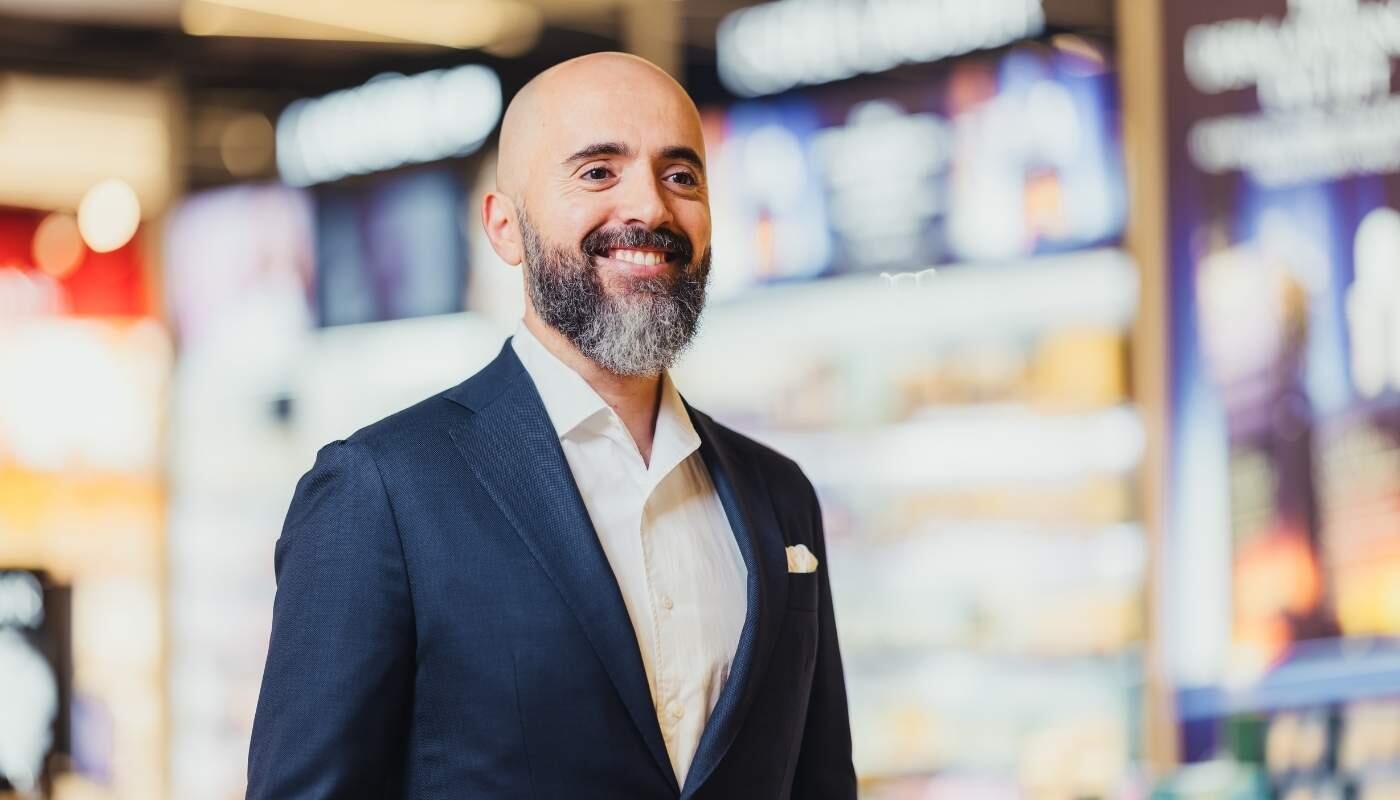 Store Manager im Einzelhandel – professionell und kundenorientiert Ein selbstbewusster Store Manager lächelt zufrieden in einem modernen Ladenumfeld – die Szene vermittelt Professionalität, Vertrauen und Führungskompetenz.