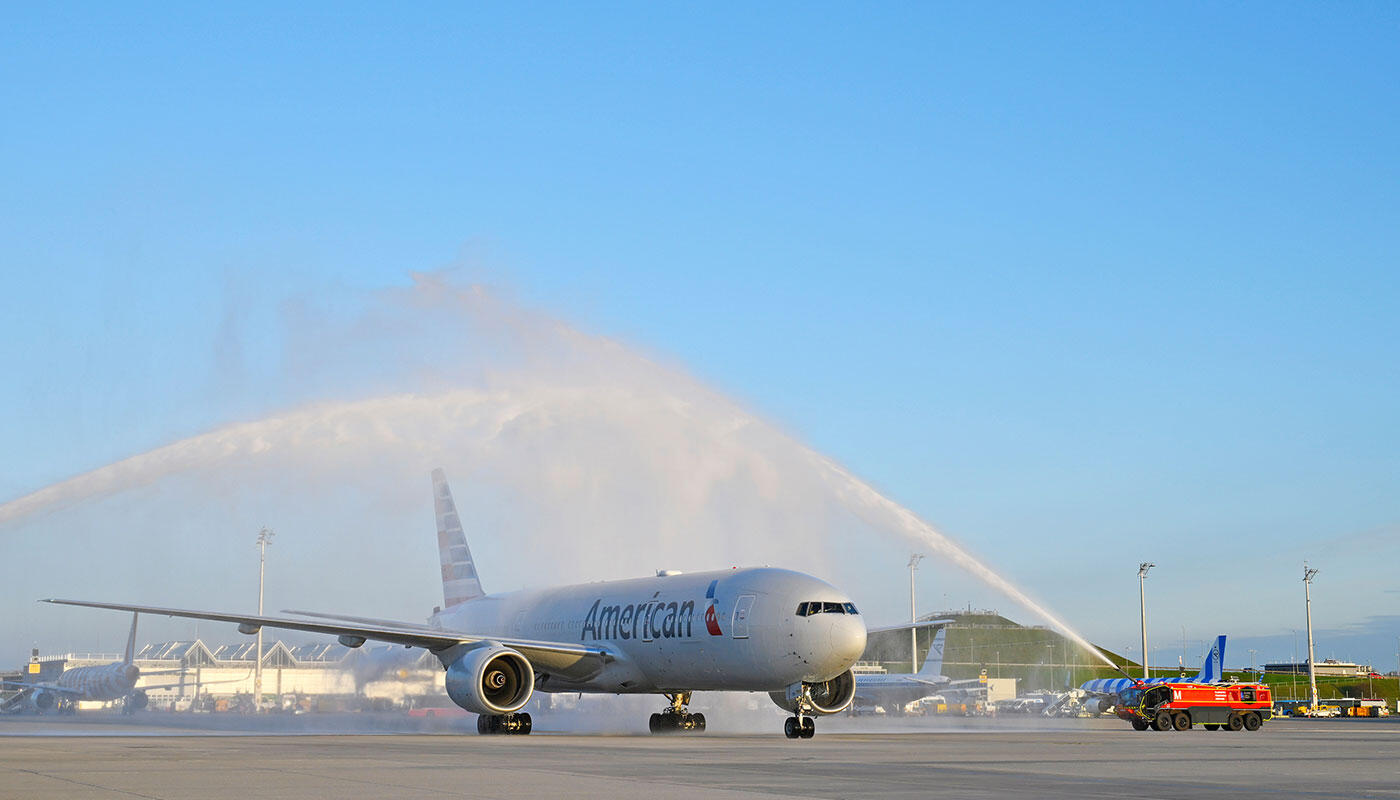 Terminal 1-Pier erfolgreich in Betrieb gegangen Flugzeug mit der Aufschrift American wird von einem Feuerwehrauto mit Wasser bespritzt
