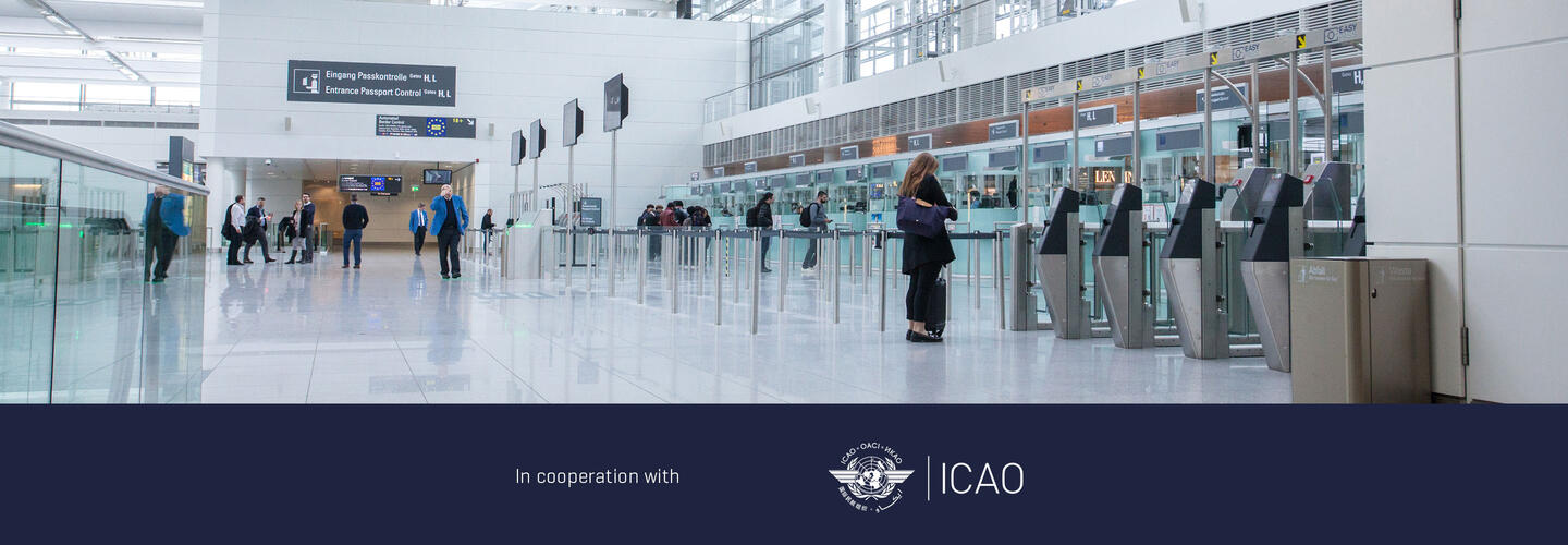 ICAO Annex 9 - Facilitation Airport passport control area with automated gates and passengers, signage for document control visible in the background.