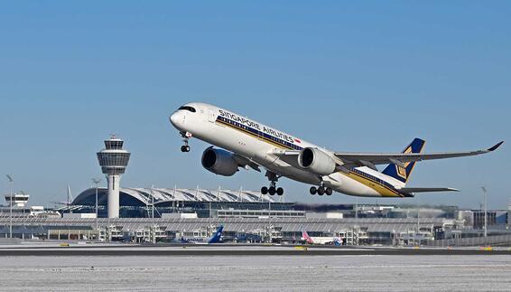 Singapore Airlines and Lufthansa aircraft on the tarmac of an international airport with terminal building and control