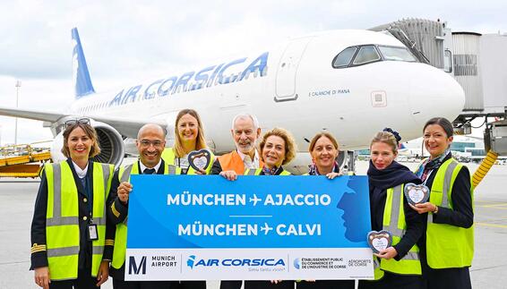 Crewmitglieder migt einem blauen Air Corsica Schild stehen vor dem Air Corsica Flugzeug
